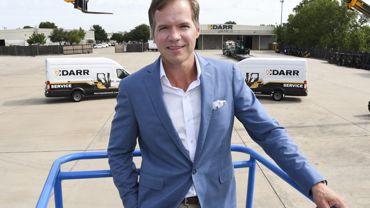 Robert Engstrom on an aerial lift with Darr service trucks in background