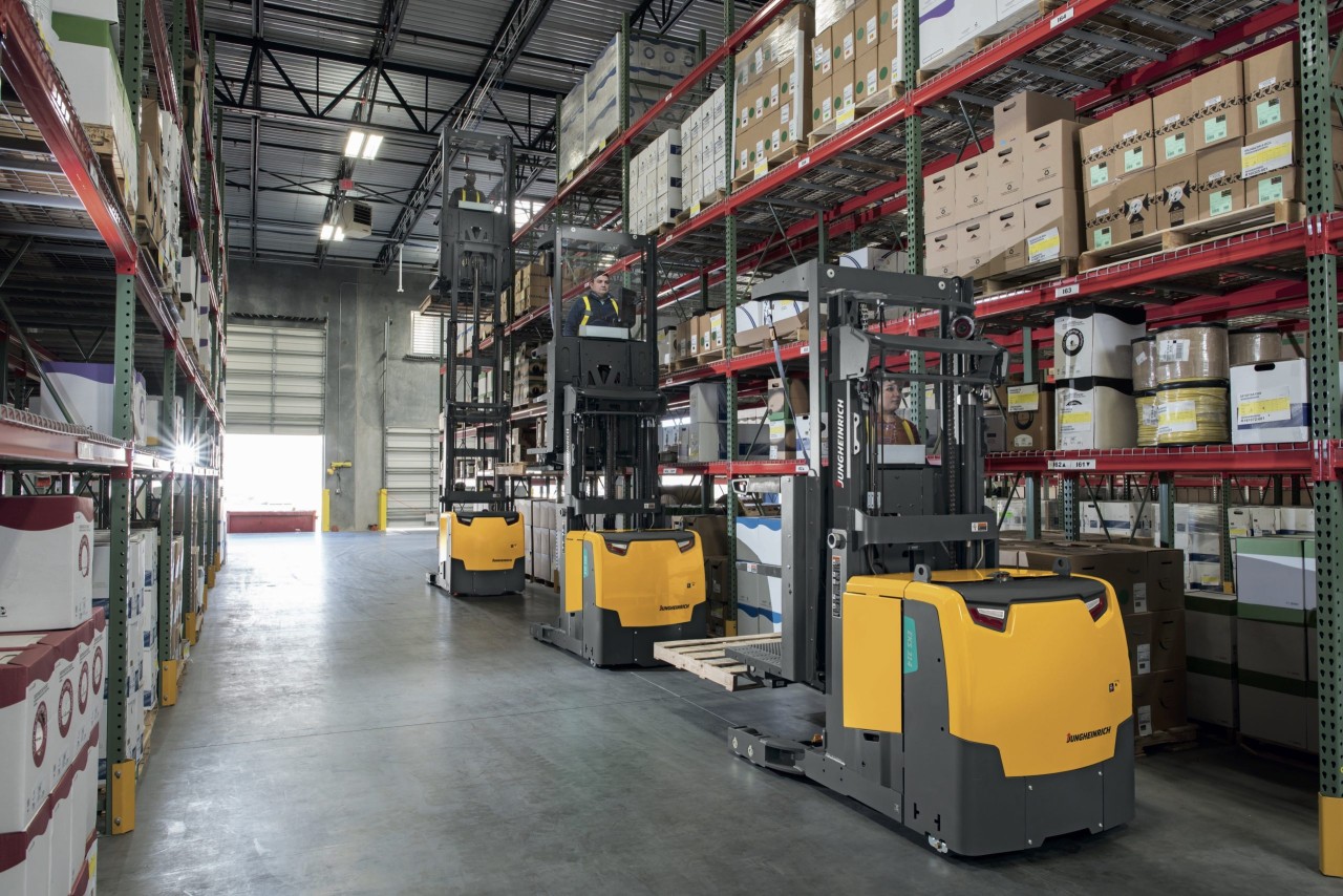 Three oder pickers in warehouse aisle