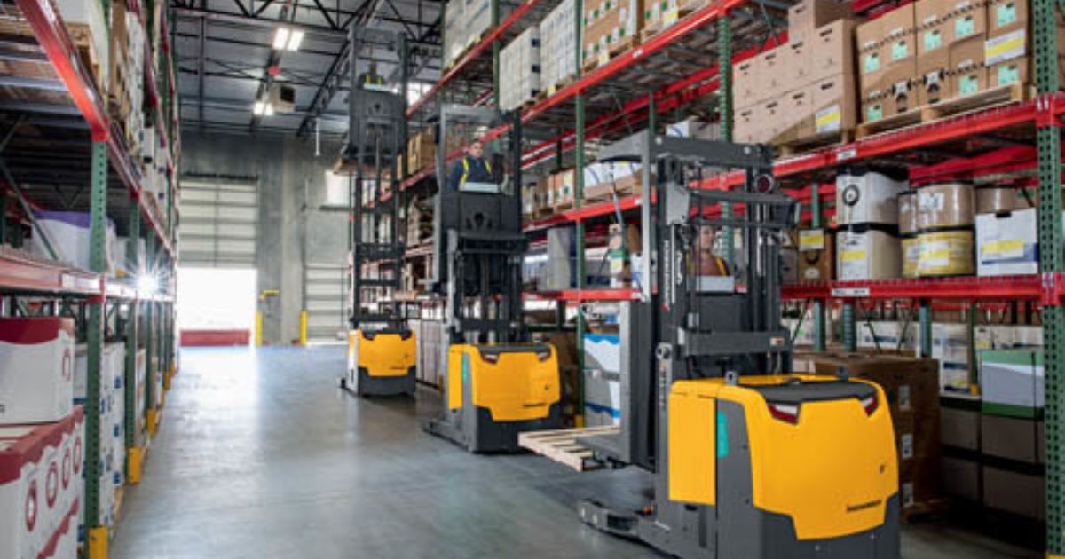 Three Jungheinrich narrow aisle forklifts in warehouse aisle